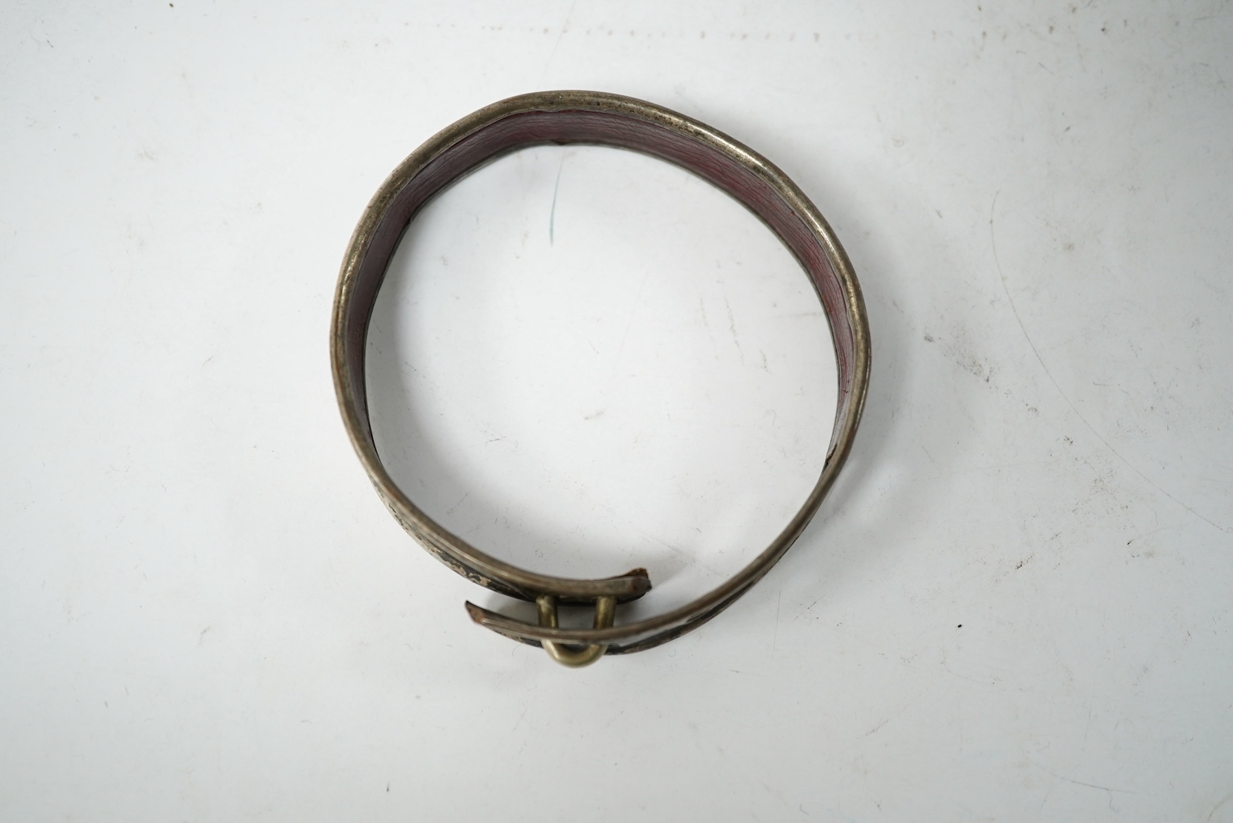 An 18th century Old Sheffield Plate and leather dog collar, 8.5cm in diameter. Condition - fair